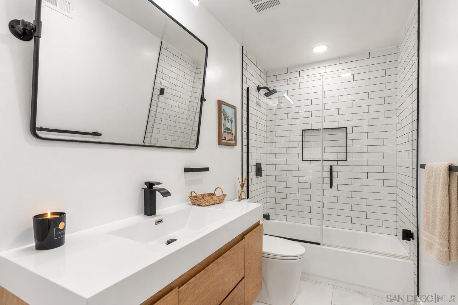 Renovated bathroom with black fixtures and glass shower