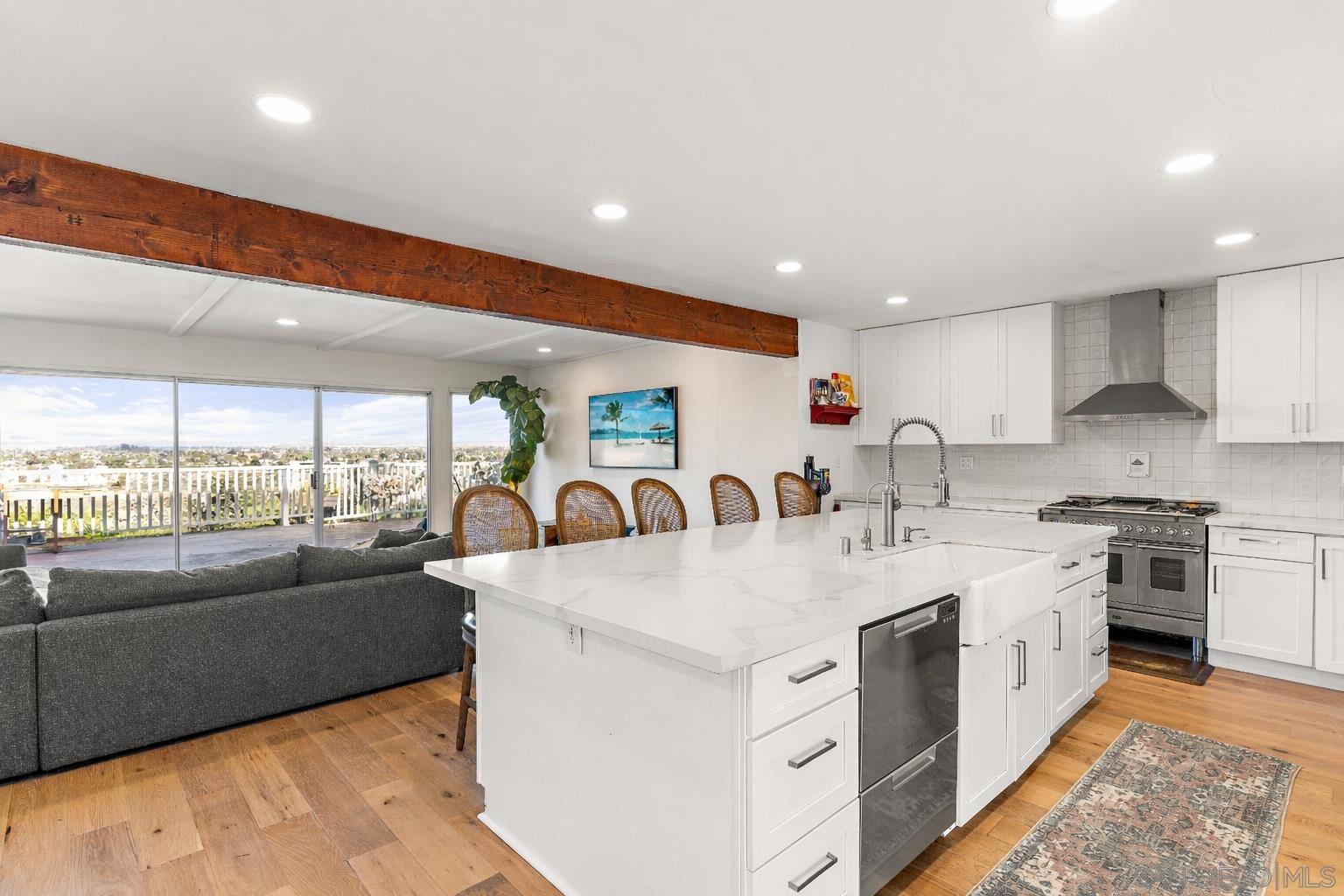 Renovated kitchen with quartz island open to living room and views