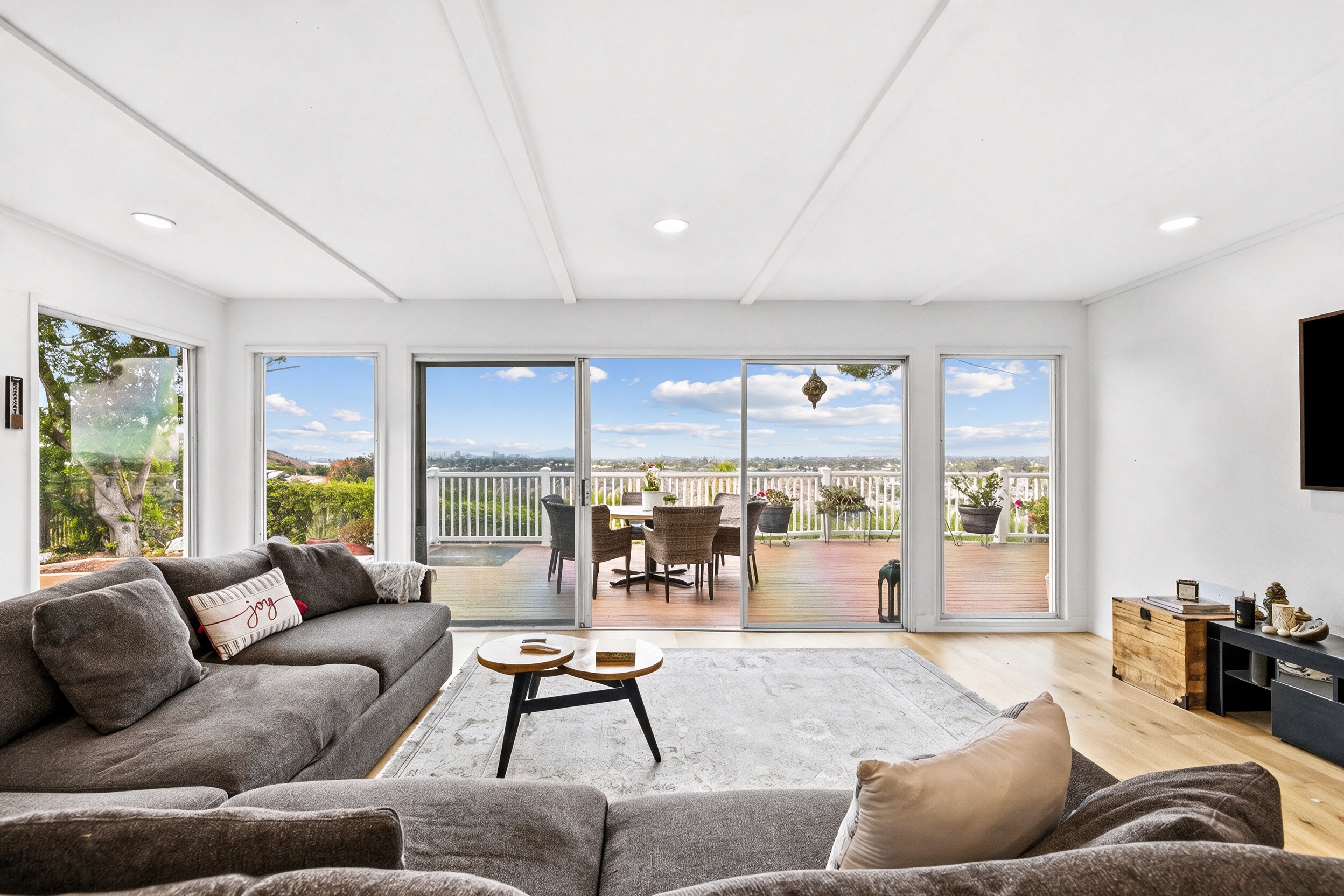 Living room with a wall of glass opening to the canyon-view deck