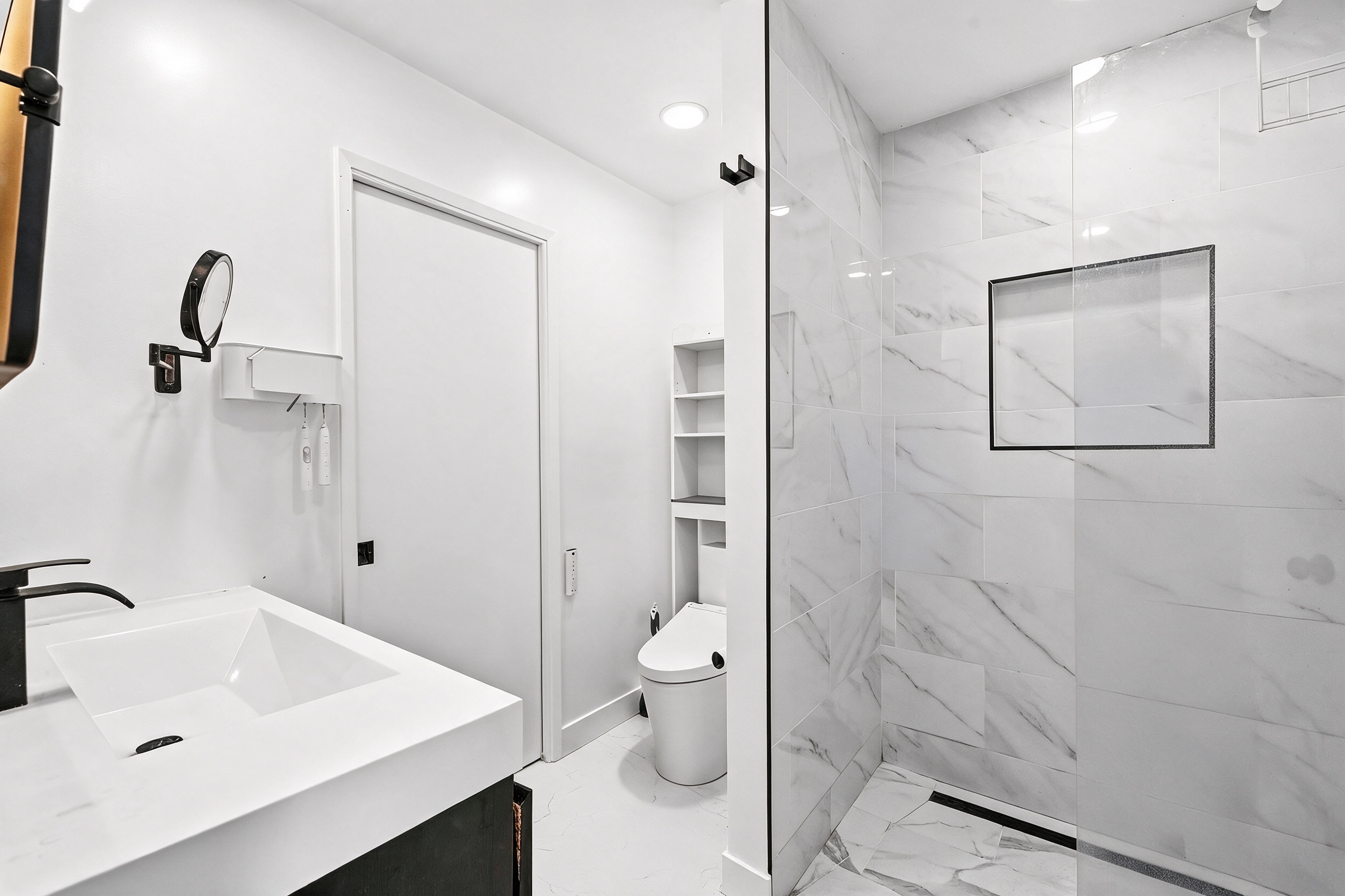 Primary ensuite bath with floating vanity and marble-tile shower